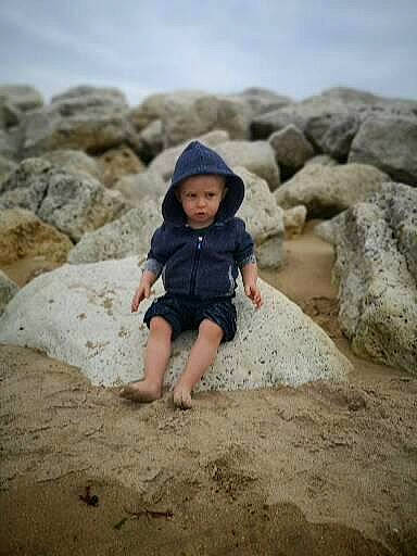 Aaron participe au concours pour gagner de l'argent avec cette photo : beach, bedrock, body_of_water, cloud, coast, formation, fun, geology, hat, headwear, landscape, people_in_nature, person, recreation, rock, sand, shore, sitting, sky, soil