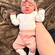 Dillon is registered to the contest to win money with this photo: baby, sleeping, infant, pink_clothing, white_socks, turban, flower_accessory, hand, blanket, soft_texture, cozy, newborn, cute, resting, human, portrait, indoors, warm_colors, baby_girl, support