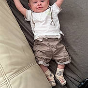 Nayël participe au concours pour gagner de l'argent avec cette photo : arms_up, baby, blanket, child, clothing, couch, cute, face, happy, home, indoor, infant, lying_down, person, relaxed, shorts, smiling, socks, soft_texture, white_shirt