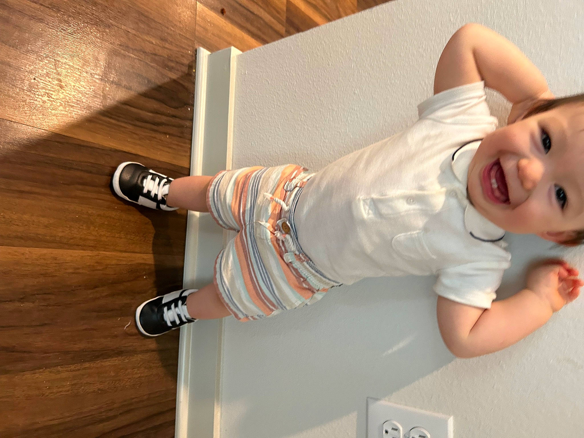 Julian is registered to the contest to win money with this photo: baby, baby_toddler_clothing, comfort, elbow, finger, flooring, foot, hardwood, human_leg, joint, joy, knee, leg, pattern, person, sleeve, smile, thigh, toddler, waist