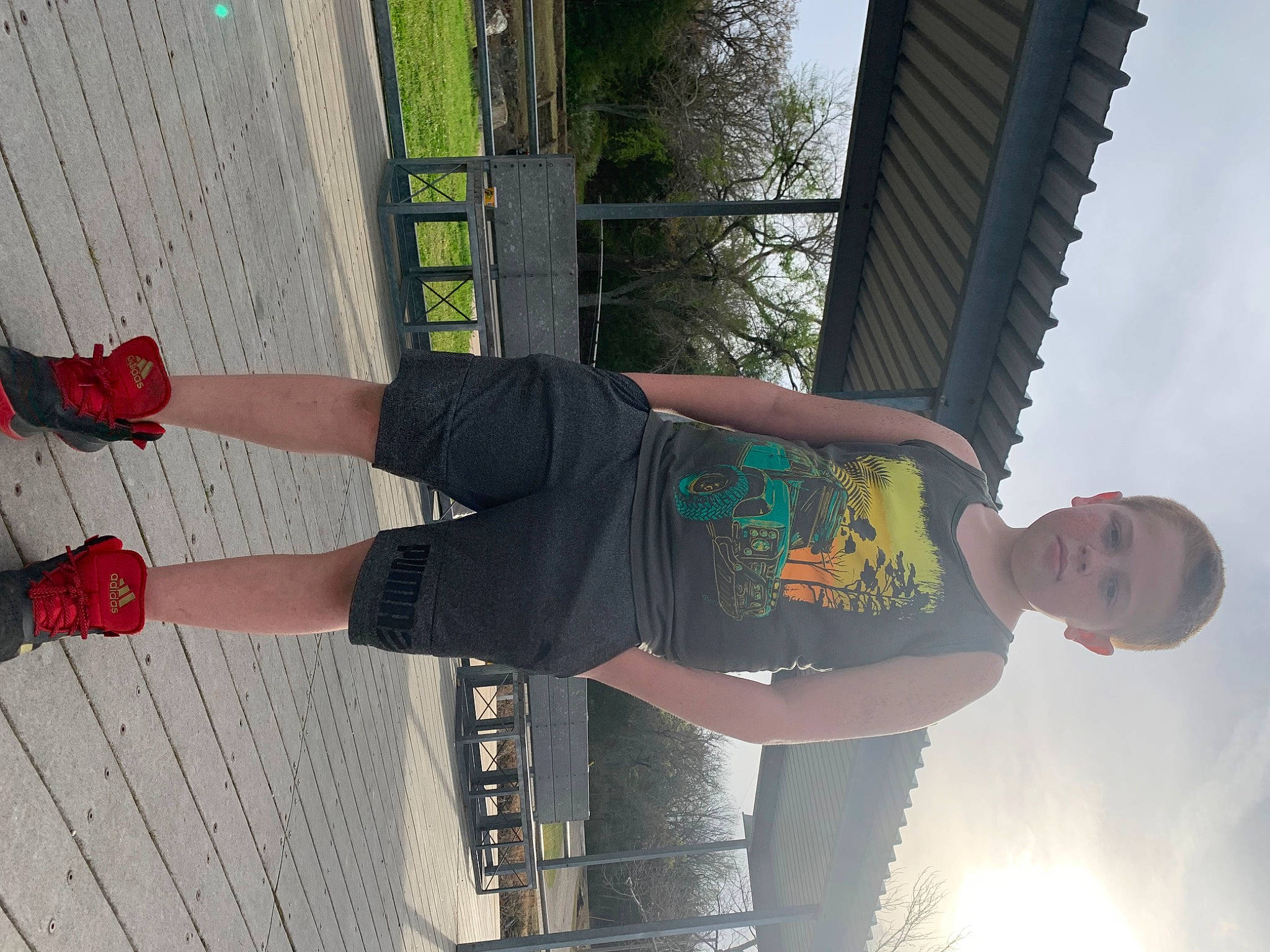 Levi is registered to the contest to win money with this photo: arm, black, carmine, elbow, foot, fun, human_leg, knee, leisure, pattern, person, red, sky, smile, street_fashion, t_shirt, thigh, tree, waist, walking_shoe