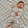 baby, infant, smiling, pajamas, bear_pattern, blanket, texture, wooden_sign, four_months, cute, happy, lying_down, child, indoors, soft_lighting, clothing, feet, hands, portrait, cozy