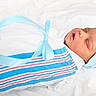 newborn, baby, sleeping, wrapped, blanket, blue_ribbon, hat, infant, peaceful, soft, white_background, portrait, cute, child, resting, closeup, swaddled, newborn_clothing, baby_boy, indoors