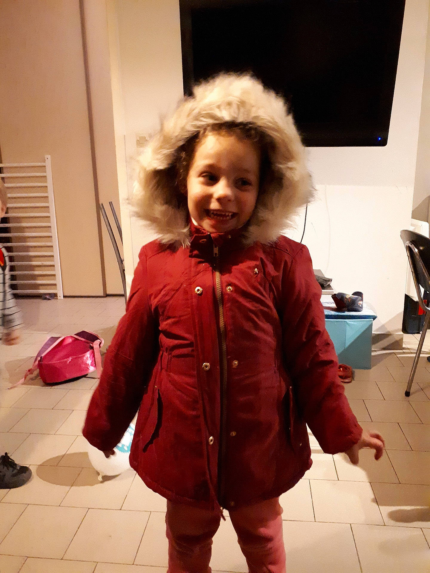 Mya participe au concours pour gagner de l'argent avec cette photo : child, coat, costume, fun, fur, girl, hair, human_hair_color, jacket, joy, material, outerwear, person, red, smile, standing, textile, top
