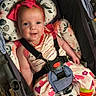 baby, child, smiling, stroller, headband, pink_bow, colorful_clothing, heart_pattern, striped_socks, floral_cushion, seatbelt, happy, indoor, toddler, cute, portrait, infant, clothing, person, seat