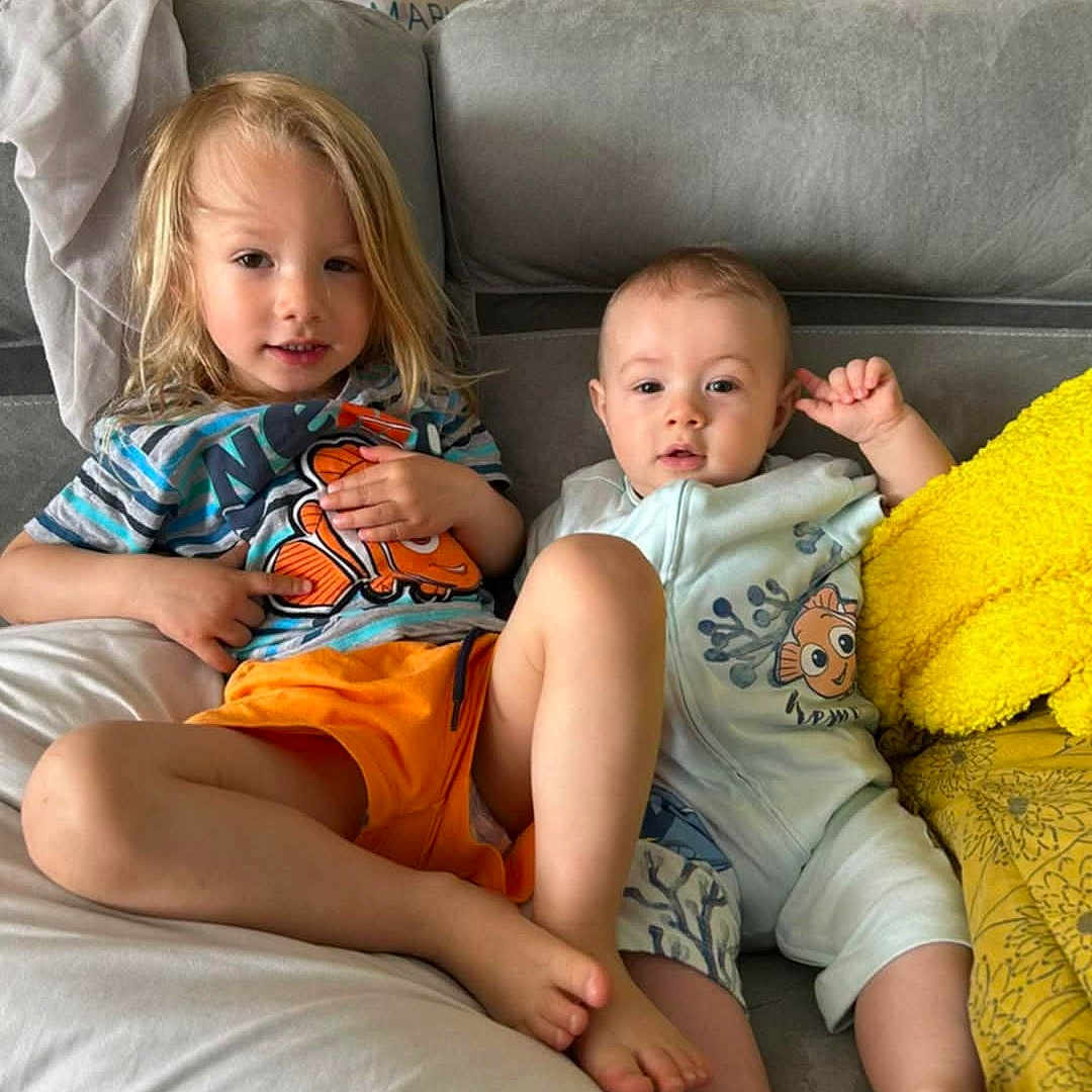 Ezio a rejoint le concours — aidez-le/la à gagner de superbes lots ! baby, blanket, casual, child, clothing, couch, cute, face, foot, furniture, hair, home, indoor, infant, person, pillow, portrait, relaxing, sibling, smiling