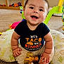 Atlas joined the competition — help win amazing prizes! baby, smiling, sitting, cushion, toy, carpet, indoors, child, black_shirt, cute, happy, playful, infant, hand, foot, face, expression, colorful, room, comfort