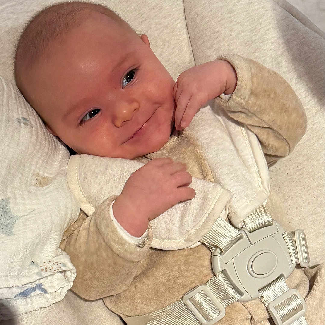 Guerlain a rejoint le concours — aidez-le/la à gagner de superbes lots ! baby, blanket, buckle, child, clothing, comfort, cushion, cute, expression, face, hand, head, indoor, infant, relaxation, seat, skin, smile, soft, young