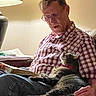 Allie joined the competition — help win amazing prizes! book, casual, cat, checkered_shirt, content, cozy, elderly, furniture, glasses, home, indoors, lamp, lap, light, man, pet, reading, relaxing, sitting, warm