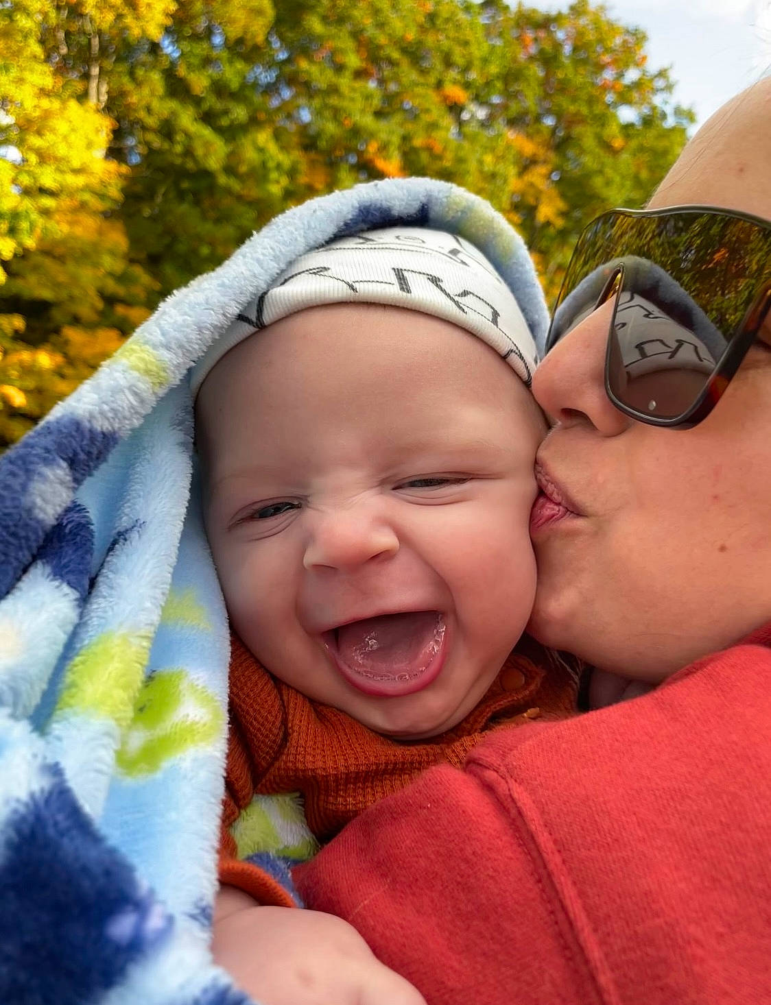 Bentley is registered to the contest to win money with this photo: cool, facial_expression, finger, fun, gesture, goggles, grass, happy, headwear, interaction, kiss, leisure, lip, mouth, nose, people_in_nature, person, skin, smile, toddler