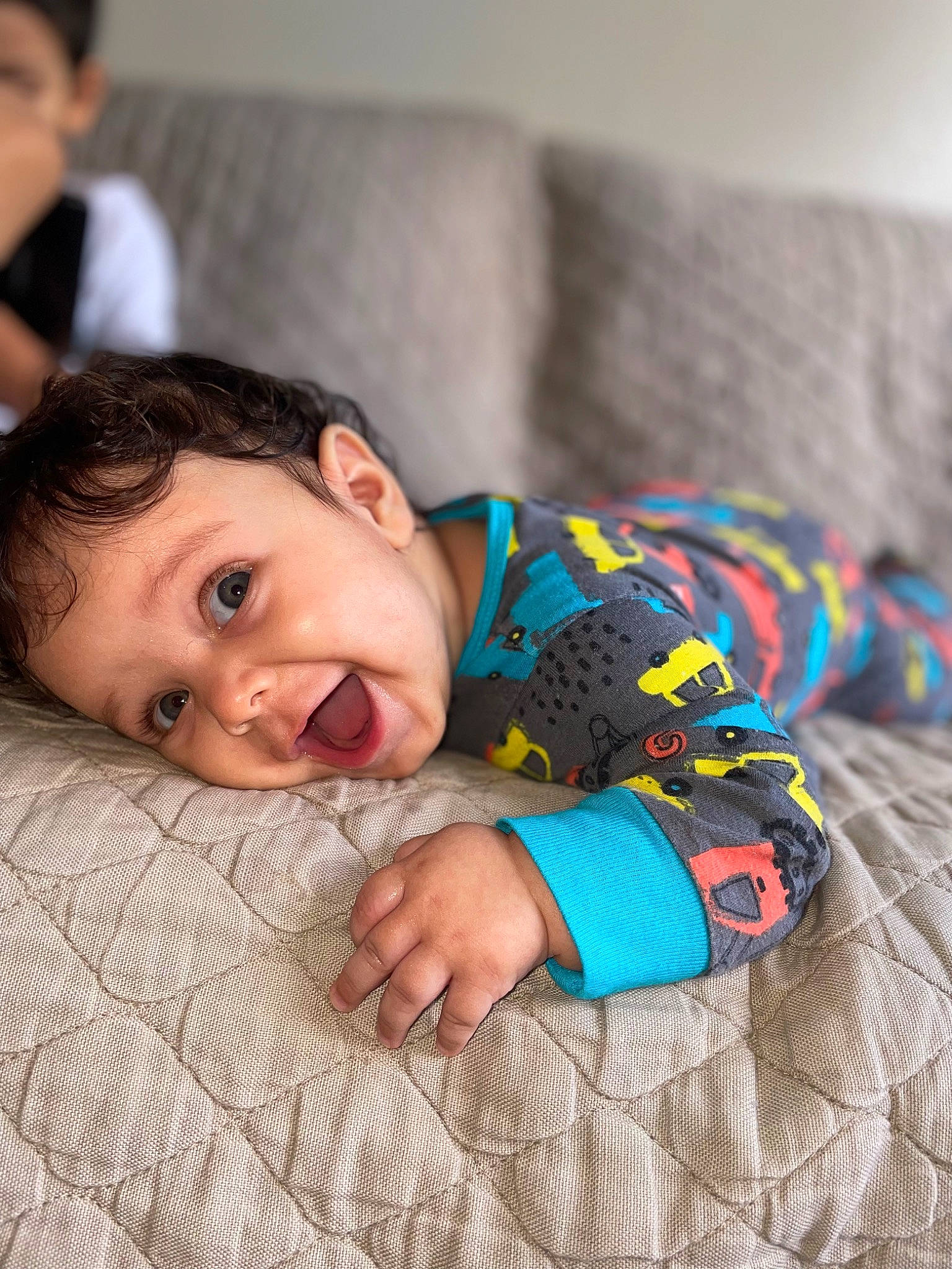 Leonidas is registered to the contest to win money with this photo: baby, baby_toddler_clothing, child, comfort, face, floor, flooring, happy, head, linens, pattern, person, plaid, room, sitting, skin, sleeve, smile, textile, toddler