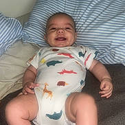 Adrean joined the competition — help win amazing prizes! baby, infant, smiling, onesie, animal_print, pillow, striped_pillow, blanket, lying_down, happy, child, cute, indoors, soft_fabric, skin, foot, hand, face, cheerful, room