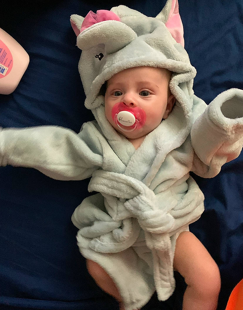 Clementine is registered to the contest to win money with this photo: arm, baby, baby_products, baby_toddler_clothing, cap, comfort, costume_hat, eye, face, fictional_character, fun, fur, gesture, hand, happy, hat, head, headwear, human_body, nose