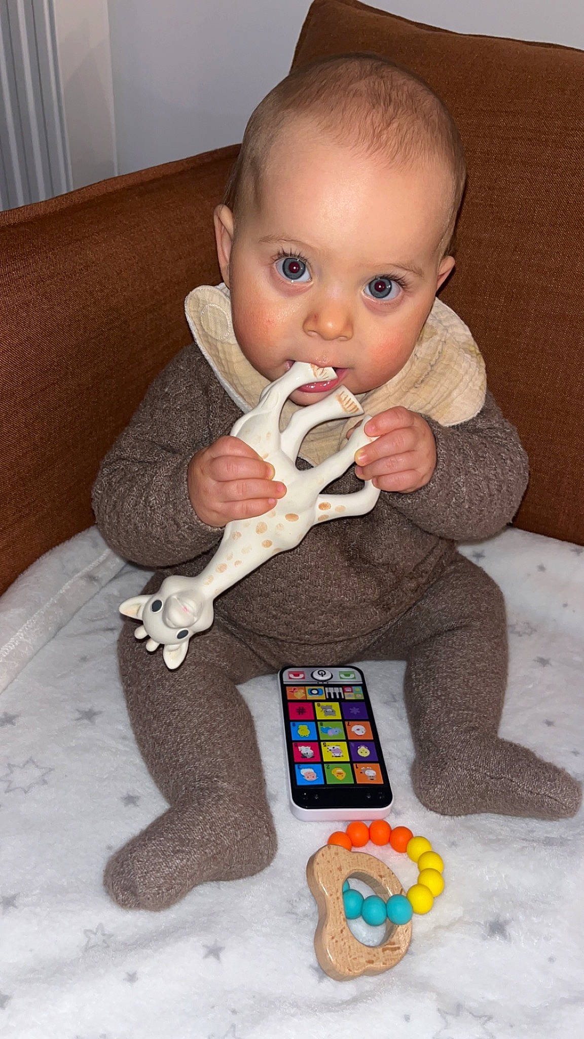 Milann participe au concours pour gagner de l'argent avec cette photo : arm, baby, baby_products, baby_toddler_clothing, baby_toys, cheek, child, comfort, curtain, flooring, fun, gadget, head, human_body, person, room, sitting, sleeve, surprise, textile