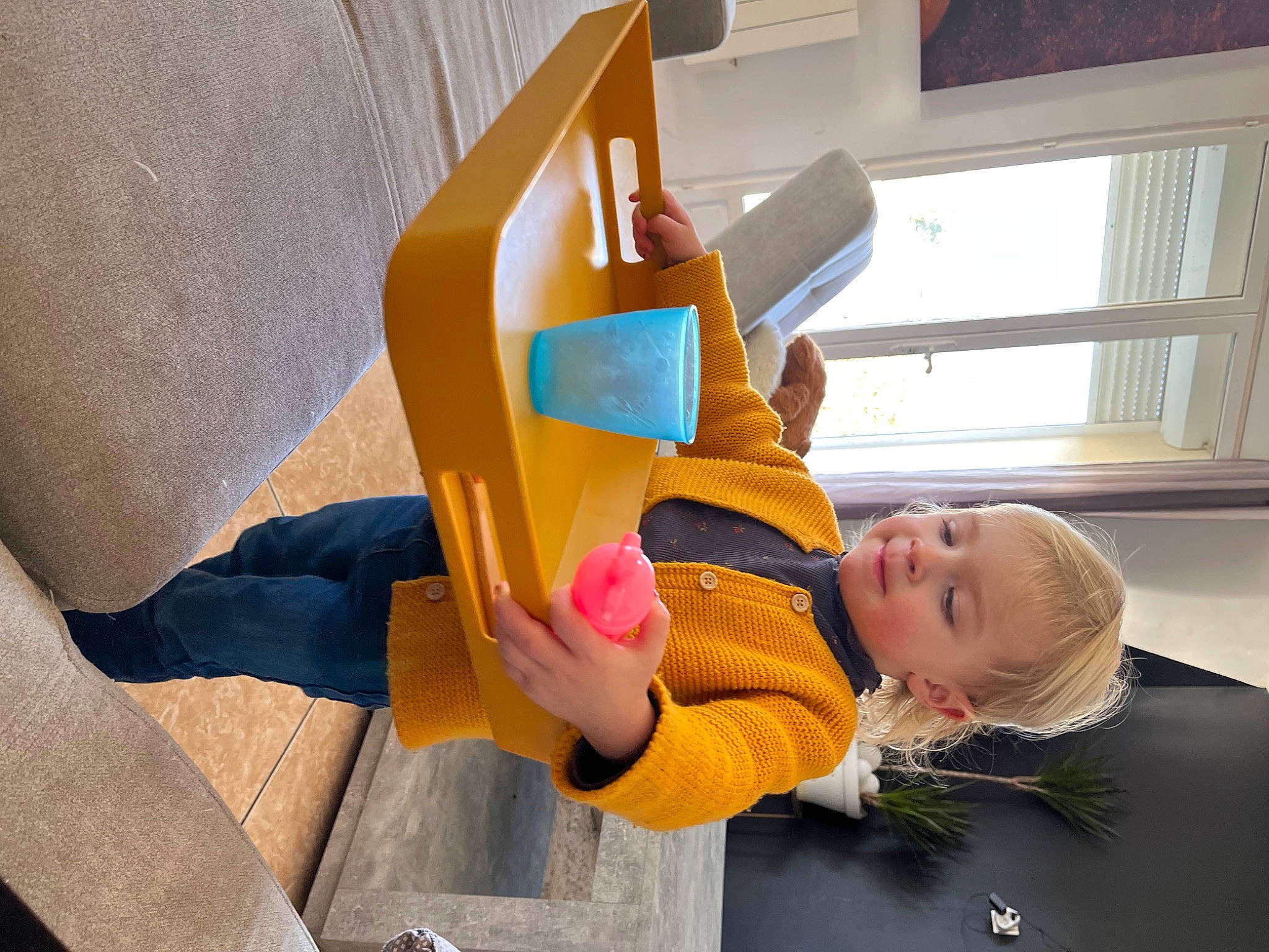 Capucine participe au concours pour gagner de l'argent avec cette photo : building, cardboard, chair, child, flooring, fun, happy, leg, leisure, paper_product, person, play, room, sitting, smile, t_shirt, toddler, visual_arts, window, wood