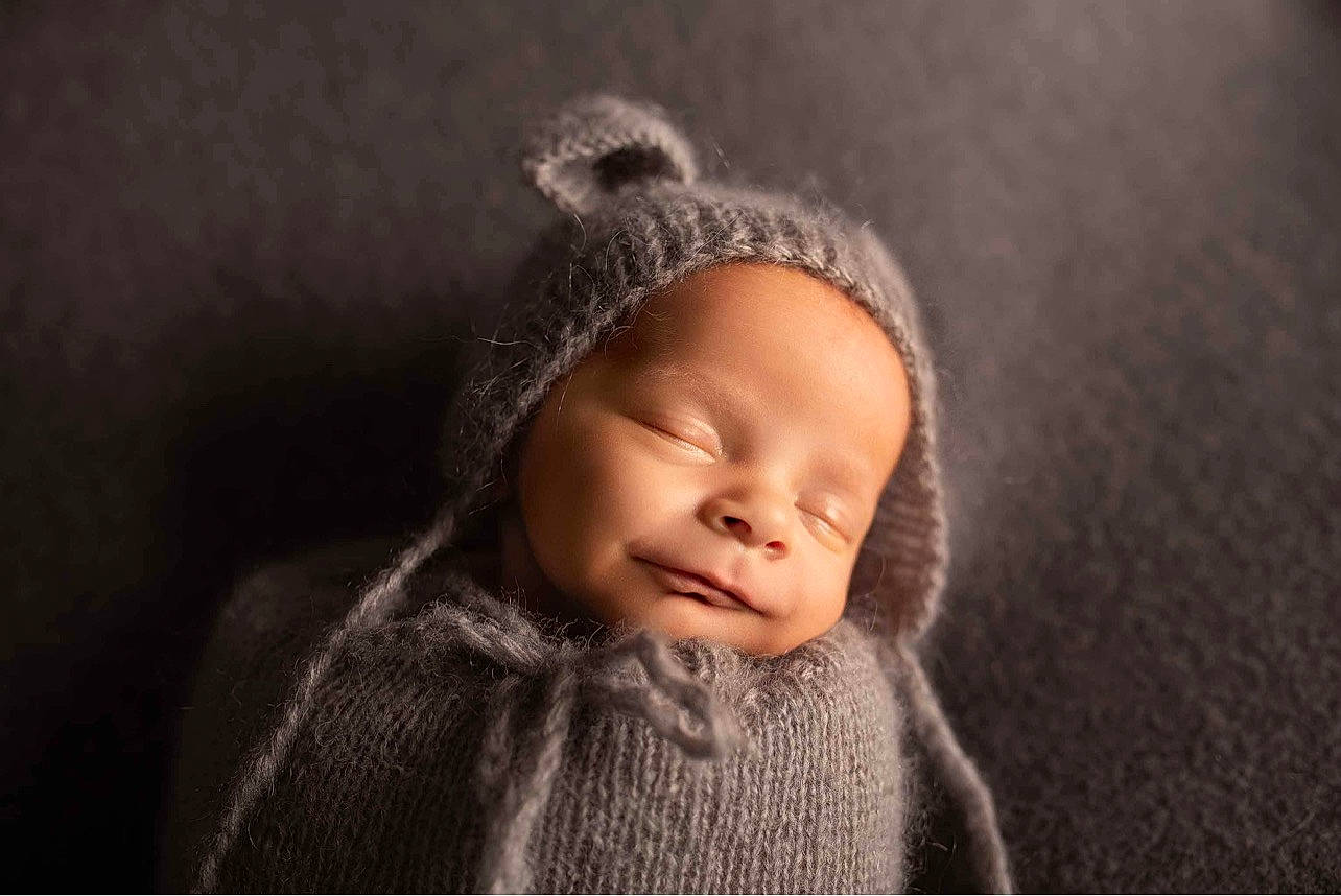 Michael is registered to the contest to win money with this photo: art, baby, beanie, cap, cheek, comfort, eye, eyelash, fashion_accessory, flash_photography, fur, grey, headgear, knit_cap, linens, monochrome_photography, person, toddler, wood, wool