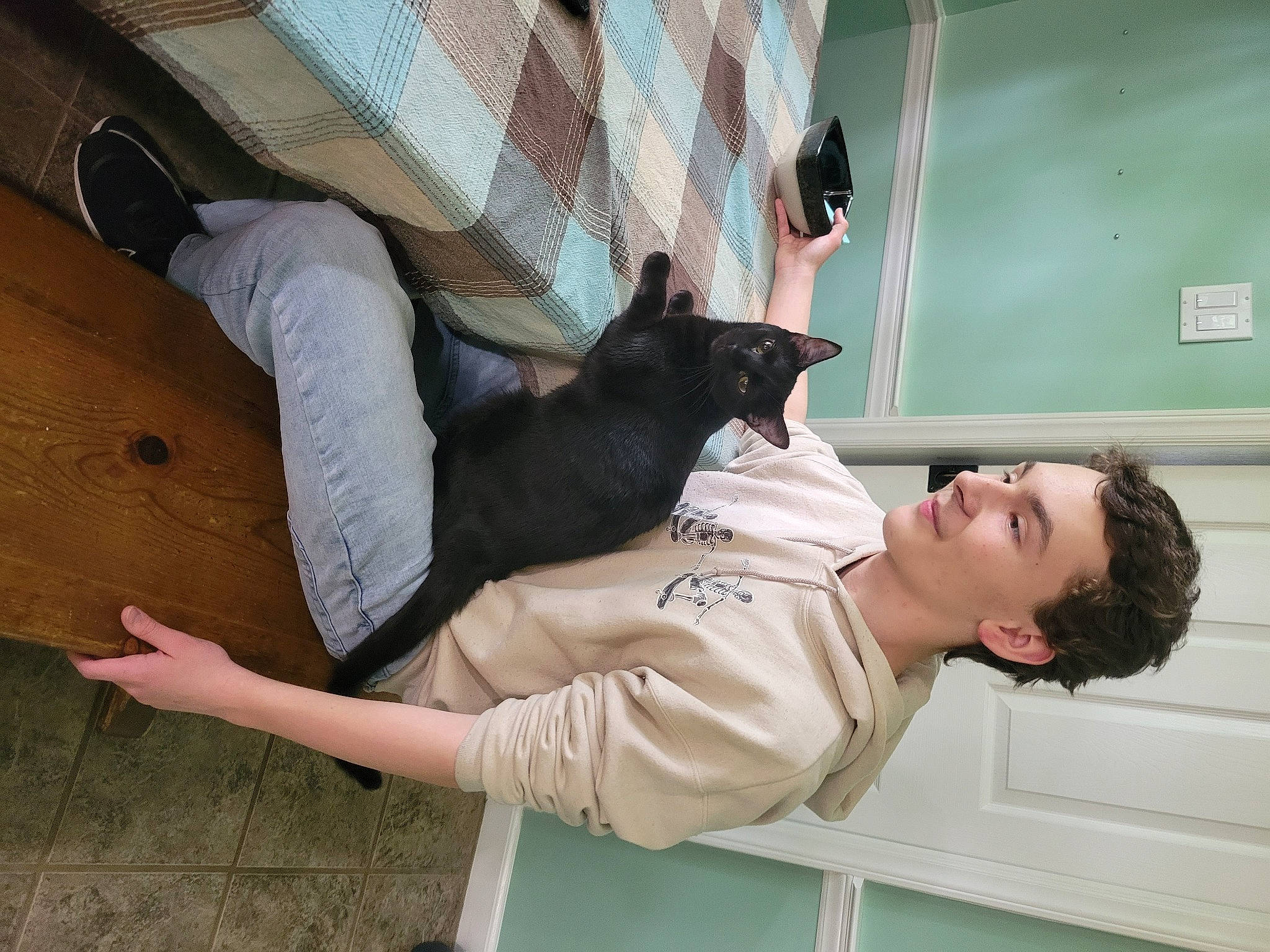 Winnie is registered to the contest to win money with this photo: cat, collar, comfort, elbow, felidae, flooring, gesture, hardwood, human_leg, room, shoulder, sleeve, small_to_medium_sized_cats, thumb, wood, wrist