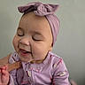 Emma is registered to the contest to win money with this photo: baby, infant, child, laughing, smiling, portrait, headband, bow, lavender, pink, baby_clothes, onesie, earring, indoor, close_up, face, hand, adult_hand, seated, happy