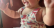 Collins joined the competition — help win amazing prizes! baby, child, smiling, happy, dress, american_flag, pattern, clapping, sitting, indoors, wooden_floor, face, cheeks, arms, eyes, person, cute, toddler, clothing, natural_light