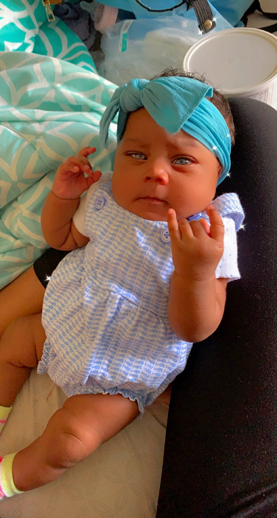 Ariyah is registered to the contest to win money with this photo: arm, baby, baby_toddler_clothing, cap, child, eyelash, finger, gesture, hand, headwear, human_leg, joint, lip, mouth, nail, organ, person, skin, textile, thigh
