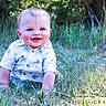 Everett is registered to the contest to win money with this photo: baby, child, smiling, crawling, grass, outdoor, nature, shirt, blue_eyes, happy, portrait, greenery, sunlight, photography, cute, young, person, face, toddler, summer