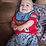 baby, bib, bugs_bunny, child, clothing, couch, cute, floral_pillow, happy, home, indoor, infant, looney_tunes, pants, person, portrait, red_shirt, relaxed, seated, smiling