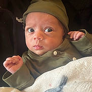 Pharaoh joined the competition — help win amazing prizes! baby, baby_girl, blanket, clothing, cozy, cute, expression, face, green_hat, green_outfit, hands, indoor, infant, newborn, person, portrait, skin, snug, warm, wide_eyes