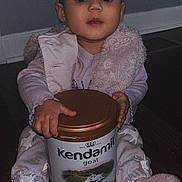 Naomi joined the competition — help win amazing prizes! baby, child, clothing, container, cozy, expression, eyes, face, floor, goat_milk, hands, indoor, infant_formula, kendamil, pajamas, product, sitting, toddler, vest, wooden_floor