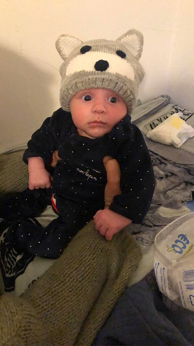 Menzo participe au concours pour gagner de l'argent avec cette photo : baby, baby_toddler_clothing, beanie, cap, cheek, child, comfort, costume_hat, face, fashion_accessory, fur, headwear, knit_cap, outerwear, pattern, person, room, sitting, skin, sleeve