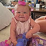 baby, child, hair_rollers, pink, purple, smiling, indoors, bed, dresser, toiletries, cute, playing, person, infant, happy, skin, furniture, room, accessories, hair_care