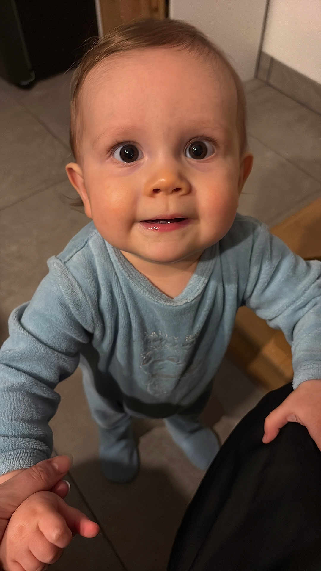 Loëvann a rejoint le concours — aidez-le/la à gagner de superbes lots ! baby, child, pajamas, blue_clothing, floor, tile_floor, hand, holding_hand, indoor, person, face, eyes, smile, cute, infant, young_child, portrait, standing, home, closeup