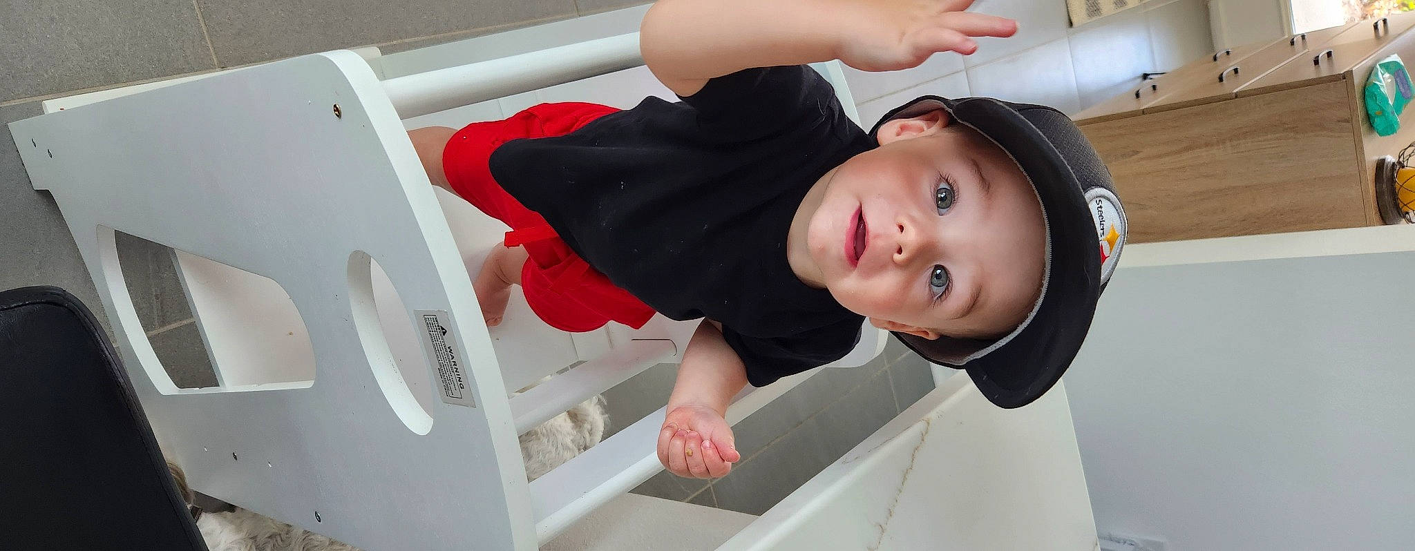 Jett is registered to the contest to win money with this photo: baby, baby_products, baby_toddler_clothing, cap, child, comfort, elbow, fun, happy, hat, headwear, person, room, sitting, sleeve, smile, t_shirt, toddler, window