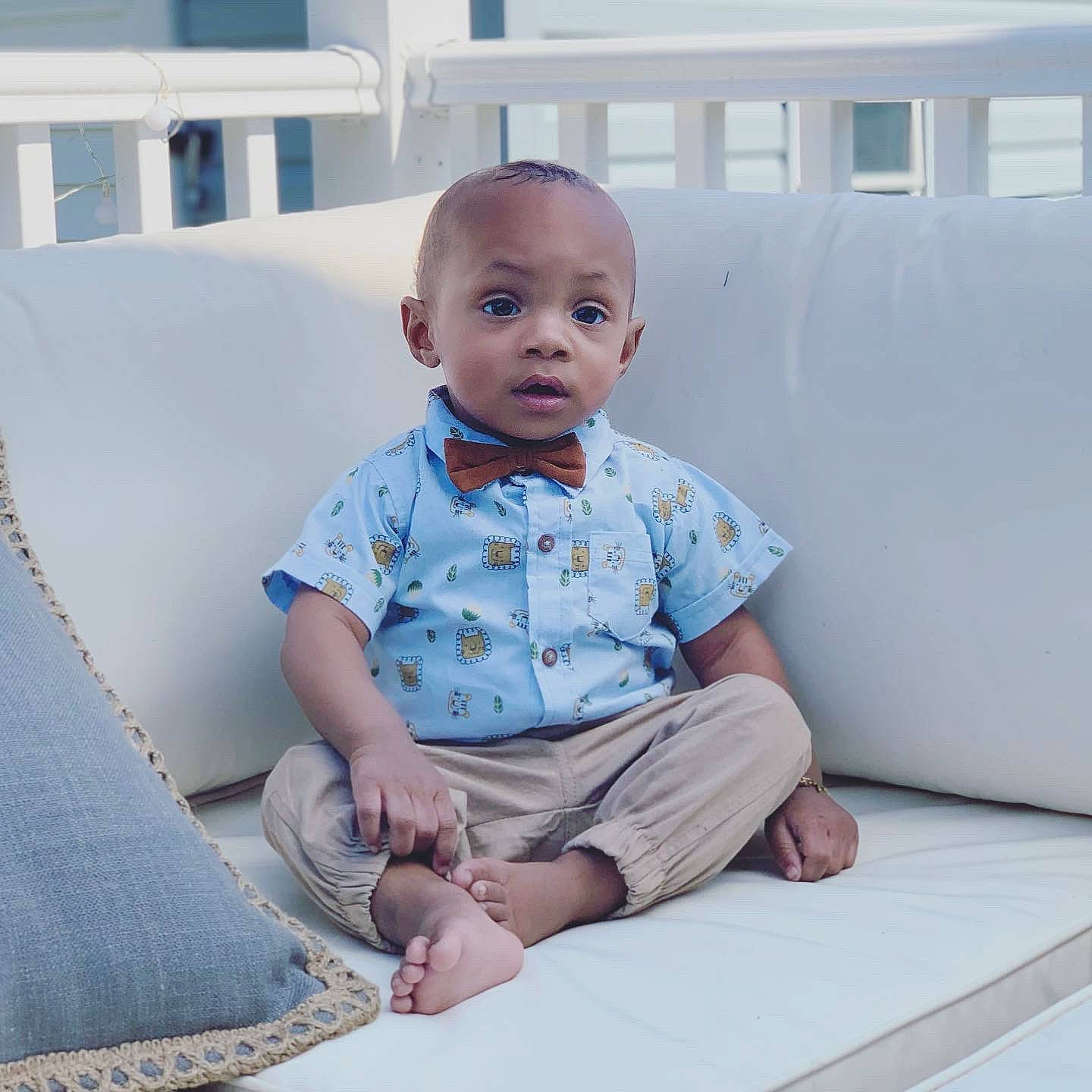 Messiah is registered to the contest to win money with this photo: baby, baby_toddler_clothing, child, comfort, electric_blue, flooring, fun, happy, human_leg, knee, pattern, person, room, sitting, skin, sleeve, standing, t_shirt, toddler, vacation