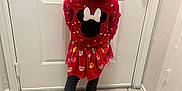 Naleighna is registered to the contest to win money with this photo: child, girl, smile, red_dress, minnie_mouse, indoor, door, tile_floor, crocs, hair_bow, curly_hair, standing, happy, casual_clothing, playful, cute, person, feet, head, fashion