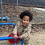 Amiel joined the competition — help win amazing prizes! child, toddler, smiling, playground, play_equipment, outdoor, happy, afro, jacket, denim_jacket, red, blue, fence, leaves, dirt, person, casual_clothing, young_child, daylight, park