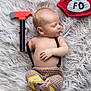 baby, newborn, infant, sleeping, toy_hammer, firefighter_hat, crochet_hat, fur_rug, blanket, bare_chest, crochet_pants, hand, feet, portrait, soft_lighting, closeup, props, cute, peaceful, studio_photo