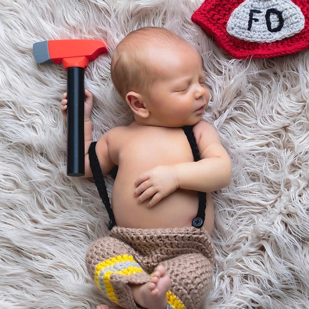 Callum joined the competition — help win amazing prizes! baby, bare_chest, blanket, closeup, crochet_hat, crochet_pants, cute, feet, firefighter_hat, fur_rug, hand, infant, newborn, peaceful, portrait, props, sleeping, soft_lighting, studio_photo, toy_hammer