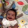 baby, smiling, play_mat, toy, colorful, infant, happy, child, lying_down, soft_toy, fabric, pattern, indoor, cute, person, animal_toy, decor, play_area, young, cheerful