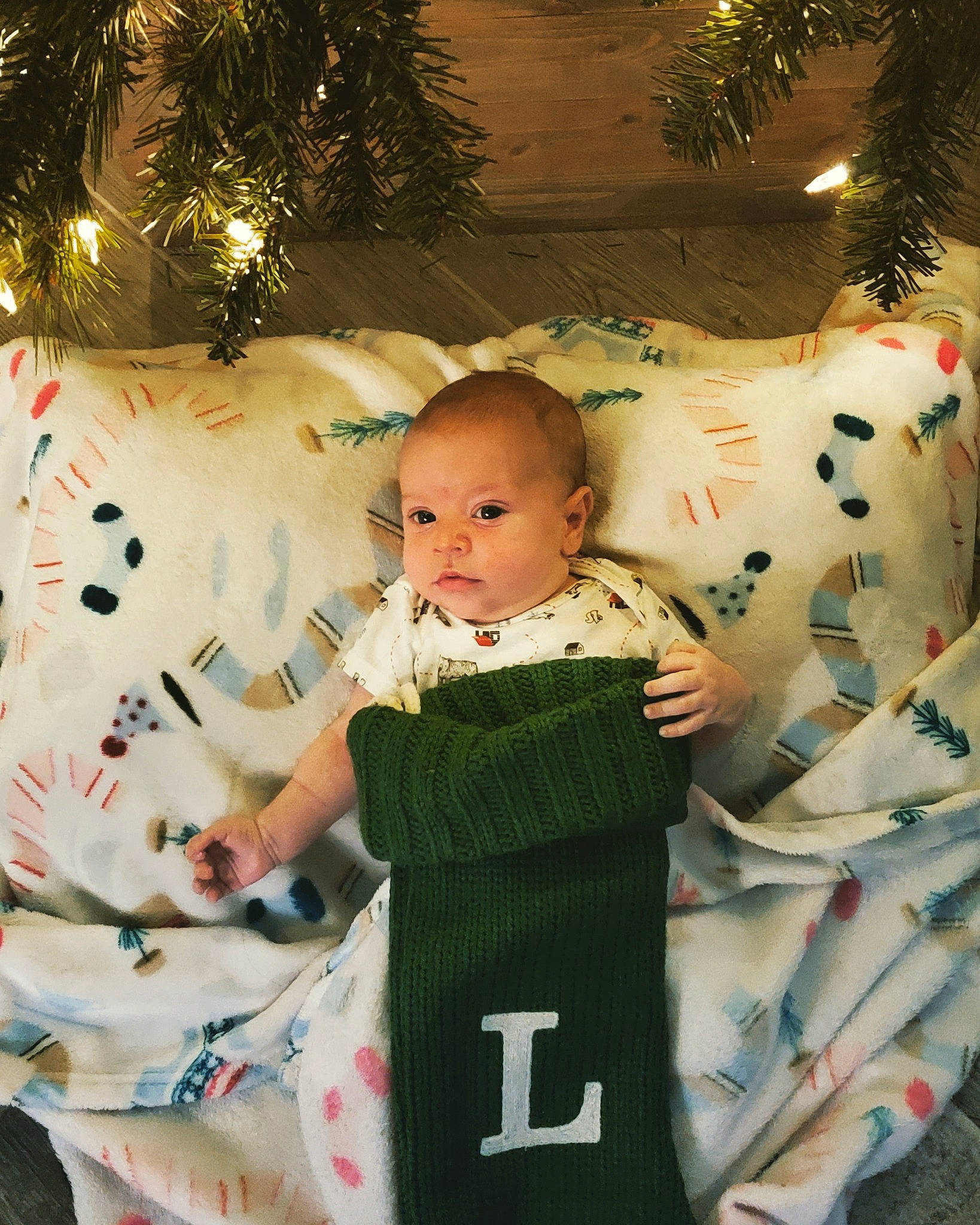 Landry is registered to the contest to win money with this photo: baby, baby_toddler_clothing, beauty, child, christmas_ornament, christmas_tree, event, facial_expression, happy, head, holiday, human_body, ornament, pattern, people, person, sitting, sleeve, t_shirt, toddler