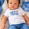 baby, blanket, blue, child, curly_hair, cute, face, fluffy, indoor, infant, jeans, lying_down, photography, portrait, smiling, stuffed_animal, teddy_bear, toy, white_shirt, wide_eyed