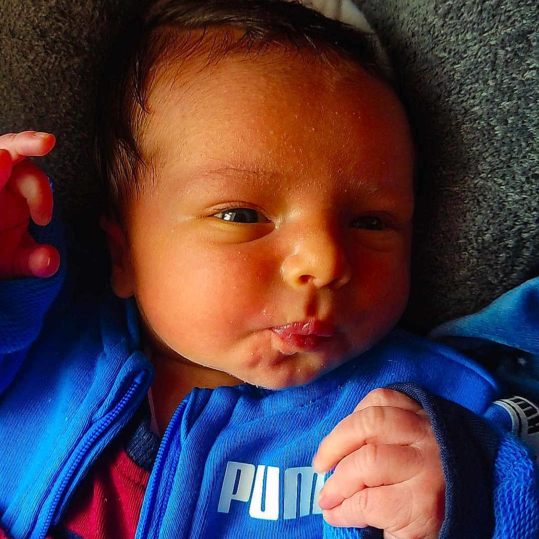 Kaïden a rejoint le concours — aidez-le/la à gagner de superbes lots ! baby, blanket, blue_jacket, closeup, clothing, cushion, cute, expression, face, hand, head, indoor, infant, newborn, person, portrait, puma_logo, skin, soft_texture, warm