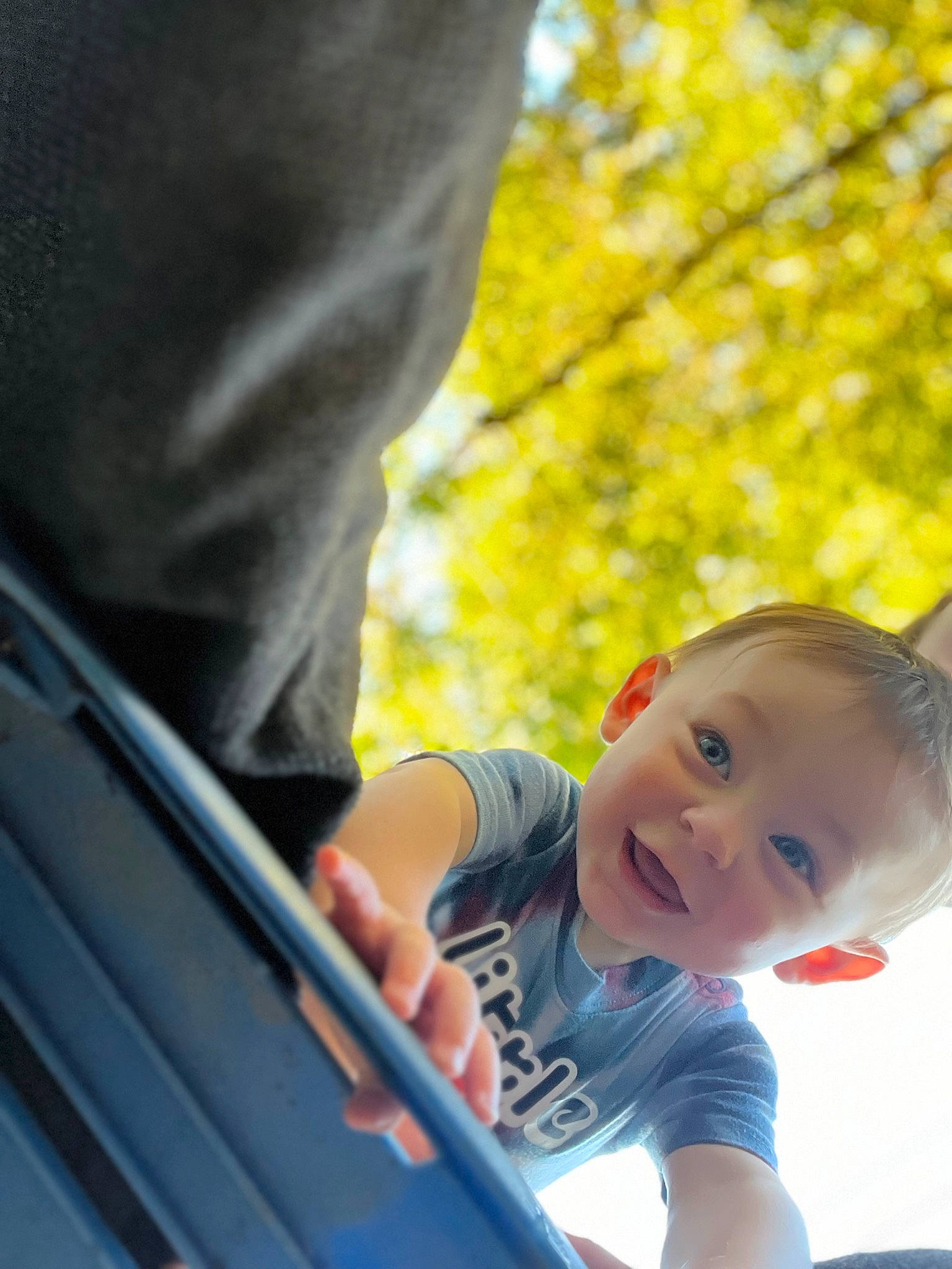 Grayson is registered to the contest to win money with this photo: auto_part, automotive_exterior, baby, baby_toddler_clothing, child, electric_blue, fun, grass, hand, happy, leisure, people_in_nature, person, plant, recreation, sitting, t_shirt, toddler, tree, vacation