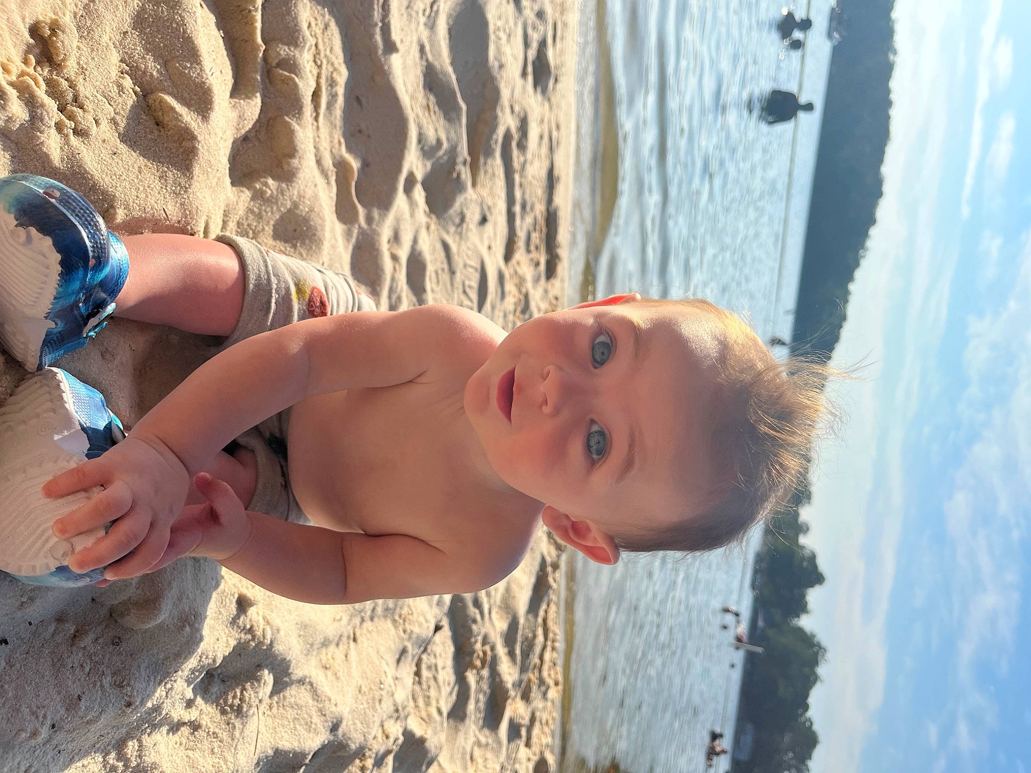 Grayson joined the competition — help win amazing prizes! azure, barechested, beach, blue, body_of_water, hair, happy, human_body, leg, leisure, light, people_in_nature, people_on_beach, person, sky, smile, sunlight, thigh, toddler, water