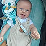 baby, smiling, plush_toy, koala, striped_overalls, white_shirt, lying_down, blue_background, happy, infant, child, cute, face, hand, pacifier_clip, button, fabric, soft_toy, closeup, indoors