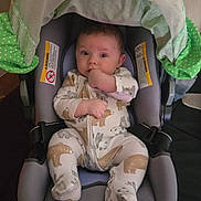Mack is registered to the contest to win money with this photo: animal_print, baby, car_seat, child, comfort, curious, cute, fabric, face, green_canopy, hand, head_support, indoor, infant, looking, pajamas, polka_dot, seat_belt, sitting, small