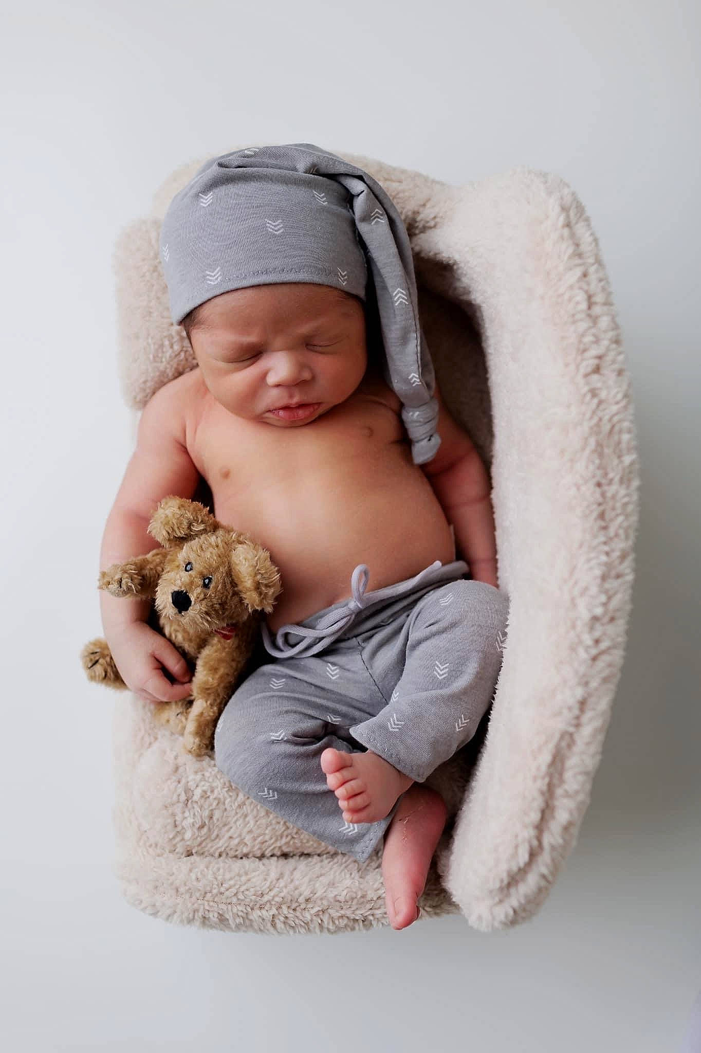 Khy is registered to the contest to win money with this photo: baby, baby_sleeping, baby_toddler_clothing, beige, cap, child, comfort, fashion_accessory, fur, headwear, linens, person, plush, sitting, skin, smile, stuffed_toy, teddy_bear, textile, toddler