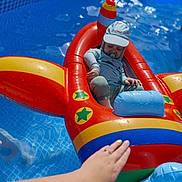 Milan participe au concours pour gagner de l'argent avec cette photo : toddler, child, inflatable, pool, water, sun_hat, pacifier, swimming, summer, toy, float, colorful, blue, red, yellow, hand, tattoo, relaxing, outdoor, sunlight