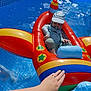 toddler, child, inflatable, pool, water, sun_hat, pacifier, swimming, summer, toy, float, colorful, blue, red, yellow, hand, tattoo, relaxing, outdoor, sunlight