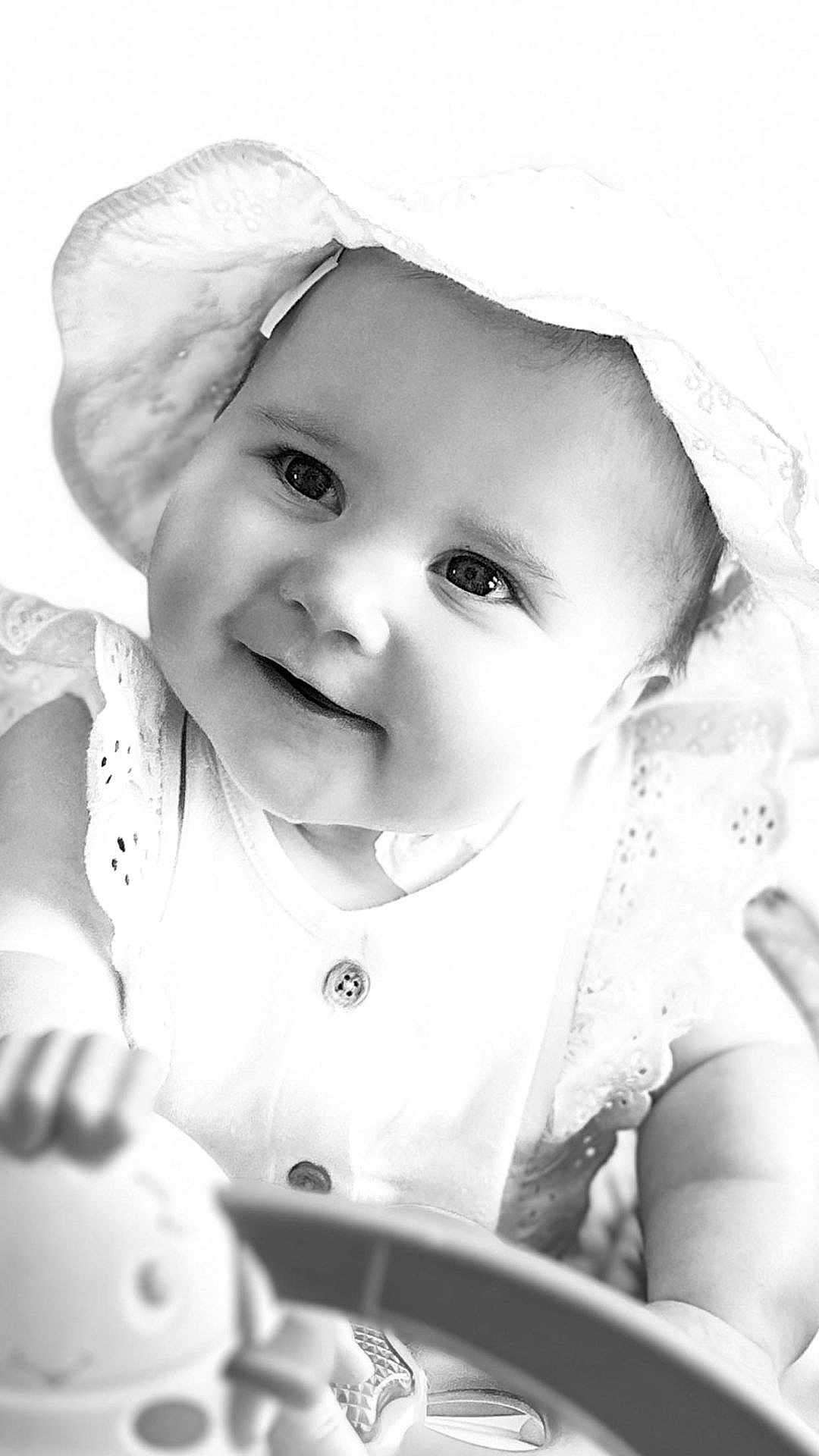 Rhea joined the competition — help win amazing prizes! baby, child, smiling, hat, toy, face, portrait, black_and_white, cute, infant, happy, close_up, clothing, button, hand, eyes, skin, person, baby_toy, playtime