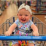 baby, child, shopping_cart, walmart, headband, bow, dress, smile, happy, toy, colorful, aisle, store, retail, infant, grip, cute, person, seatbelt, shopping